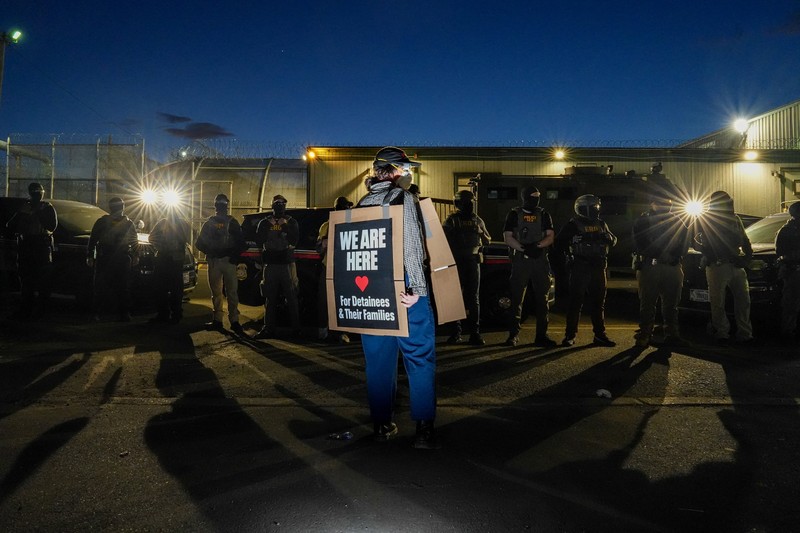 Para pengunjuk rasa berdemonstrasi di depan petugas ICE di luar Delaney Hall di Newark, New Jersey, AS, Kamis (28/5/2026). (REUTERS/Ryan Murphy)