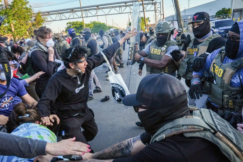 Para pengunjuk rasa berdemonstrasi di depan petugas ICE di luar Delaney Hall di Newark, New Jersey, AS, Kamis (28/5/2026). (REUTERS/Ryan Murphy)