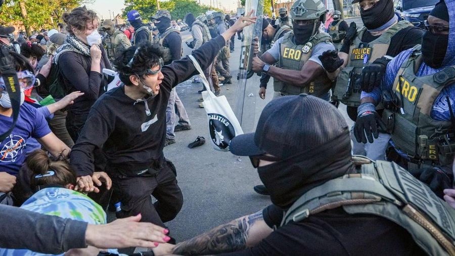 Para pengunjuk rasa berdemonstrasi di depan petugas ICE di luar Delaney Hall di Newark, New Jersey, AS, Kamis (28/5/2026). (REUTERS/Ryan Murphy)