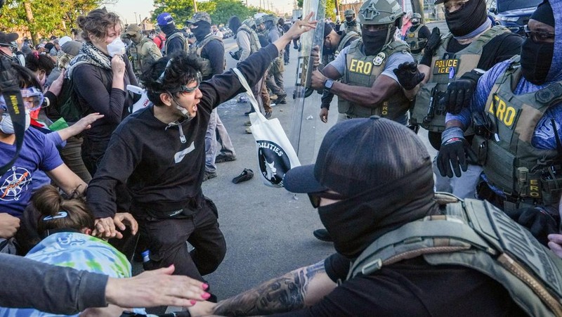 Para pengunjuk rasa berdemonstrasi di depan petugas ICE di luar Delaney Hall di Newark, New Jersey, AS, Kamis (28/5/2026). (REUTERS/Ryan Murphy)