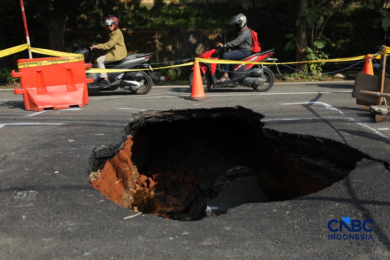 Sejumlah pengendara melewati jalan amblas di Jalan Raya Lenteng Agung, Jakarta, Jumat (29/5/2026). (CNBC Indonesia/Tri Susilo)