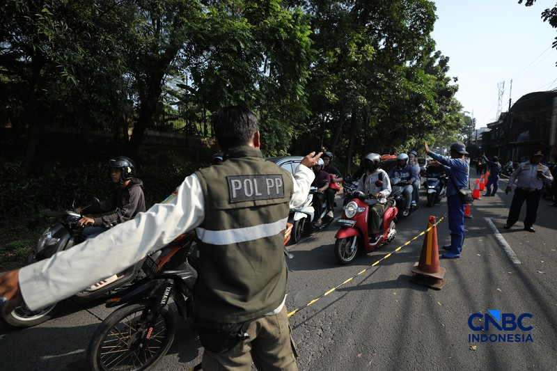 Sejumlah pengendara melewati jalan amblas di Jalan Raya Lenteng Agung, Jakarta, Jumat (29/5/2026). (CNBC Indonesia/Tri Susilo)