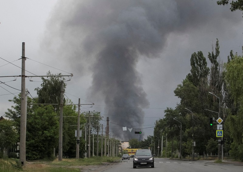 Petugas pemadam kebakaran dan jurnalis bekerja di lokasi serangan pesawat tak berawak Rusia, di tengah serangan Rusia terhadap Ukraina, di Dnipro, Ukraina, 31 Mei 2026. (REUTERS/Stringer)
