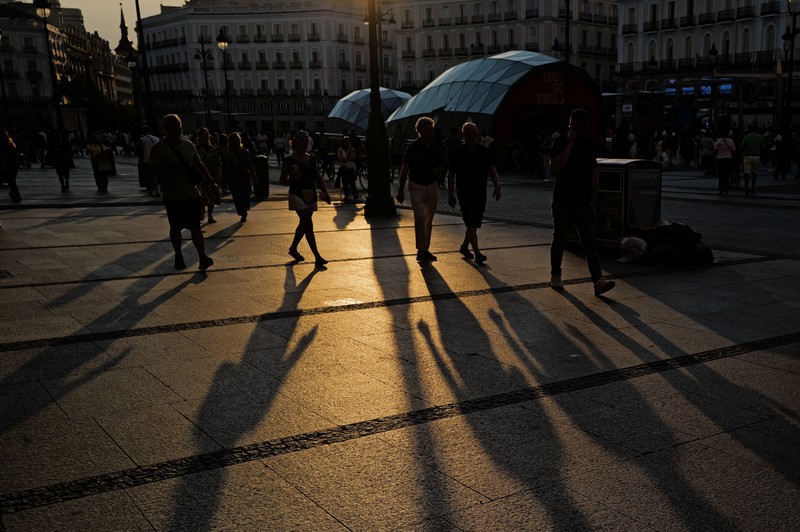 Seorang wanita dengan payung berjalan melewati panel suhu yang menunjukkan angka 42 derajat Celcius selama gelombang panas musim semi di Bilbao, Spanyol, 27 Mei 2026. (REUTERS/Vincent West)