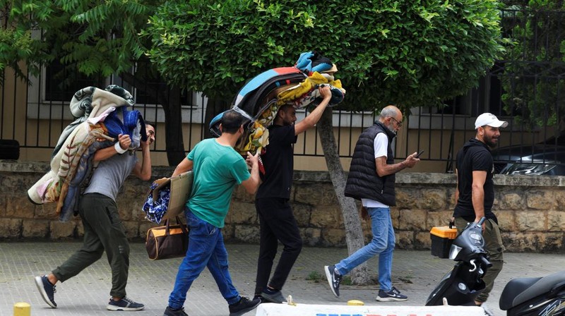 Orang-orang yang membawa barang-barang mereka berlarian saat melarikan diri dari pinggiran selatan Beirut, setelah Perdana Menteri Israel Benjamin Netanyahu memerintahkan militer untuk menyerang target di pinggiran kota, Lebanon, 1 Juni 2026.