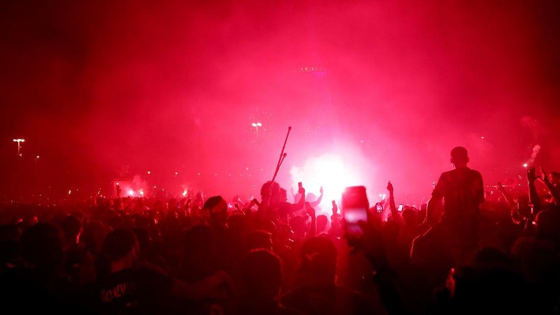 Para pendukung Paris Saint-Germain menyalakan suar saat merayakan kemenangan tim mereka usai menjuarai Liga Champions UEFA di Trocadéro, Sabtu (30/5/2026).