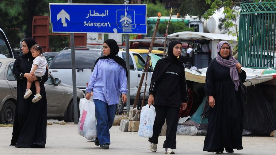 Para wanita berjalan di jalanan sementara orang-orang berhamburan melarikan diri dari pinggiran selatan Beirut, setelah Perdana Menteri Israel Benjamin Netanyahu memerintahkan militer untuk menyerang target di pinggiran kota, Lebanon, 1 Juni 2026.