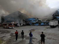Petugas pemadam kebakaran dan jurnalis bekerja di lokasi serangan pesawat tak berawak Rusia, di tengah serangan Rusia terhadap Ukraina, di Dnipro, Ukraina, 31 Mei 2026. (REUTERS/Stringer)