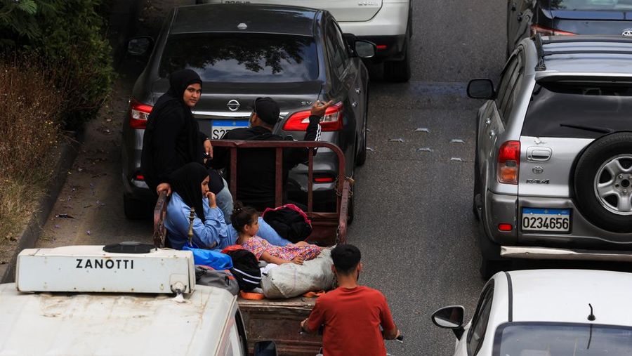 Seorang wanita dan anak-anak duduk di belakang kendaraan bermotor saat orang-orang berhamburan melarikan diri dari pinggiran selatan Beirut, setelah Perdana Menteri Israel Benjamin Netanyahu memerintahkan militer untuk menyerang target di pinggiran kota, Lebanon, 1 Juni 2026.