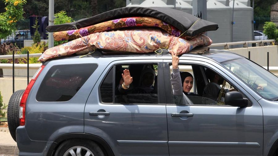 Seorang wanita memberi isyarat dari dalam mobil sementara orang-orang berhamburan melarikan diri dari pinggiran selatan Beirut, setelah Perdana Menteri Israel Benjamin Netanyahu memerintahkan militer untuk menyerang target di pinggiran kota, Lebanon, 1 Juni 2026.