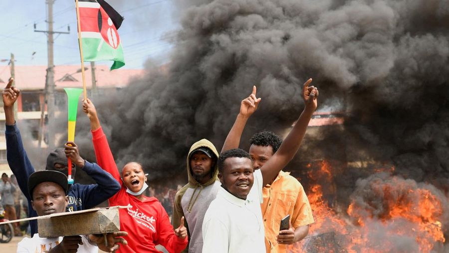 Para demonstran berkumpul di dekat barikade yang mereka buat selama protes terhadap rencana karantina Ebola yang didukung AS terkait pembangunan fasilitas berkapasitas 50 tempat tidur di pangkalan angkatan udara Kenya yang dimaksudkan untuk menampung