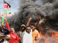Para demonstran berkumpul di dekat barikade yang mereka buat selama protes terhadap rencana karantina Ebola yang didukung AS terkait pembangunan fasilitas berkapasitas 50 tempat tidur di pangkalan angkatan udara Kenya yang dimaksudkan untuk menampung