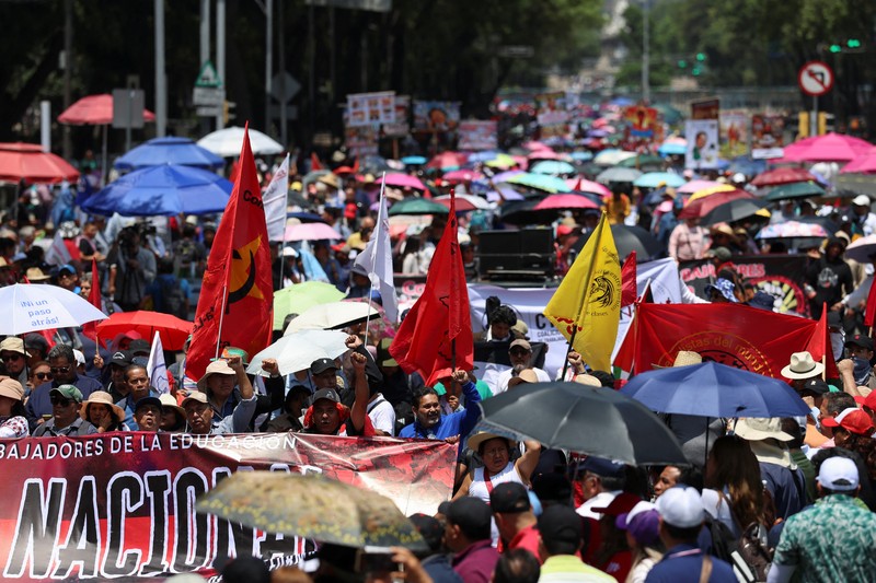 Para guru dari serikat Koordinasi Nasional Pekerja Pendidikan Meksiko (CNTE) berpawai menuju alun-alun Zocalo untuk menuntut upah dan pensiun yang lebih baik, dengan slogan