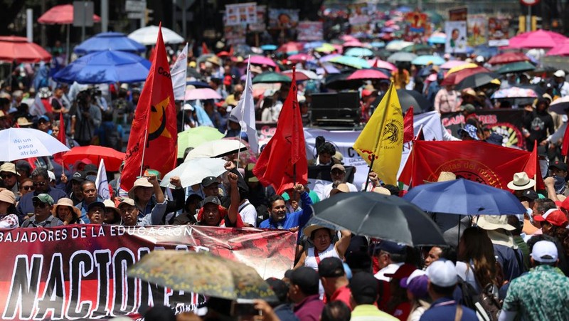 Para guru dari serikat Koordinasi Nasional Pekerja Pendidikan Meksiko (CNTE) berpawai menuju alun-alun Zocalo untuk menuntut upah dan pensiun yang lebih baik, dengan slogan