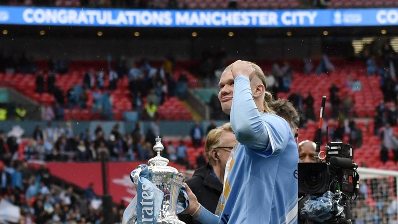 Pemain Manchester City Erling Haaland merayakan kemenangan dengan trofi Piala FA. REUTERS/Tony O'Brien. (REUTERS/TONY O BRIEN)