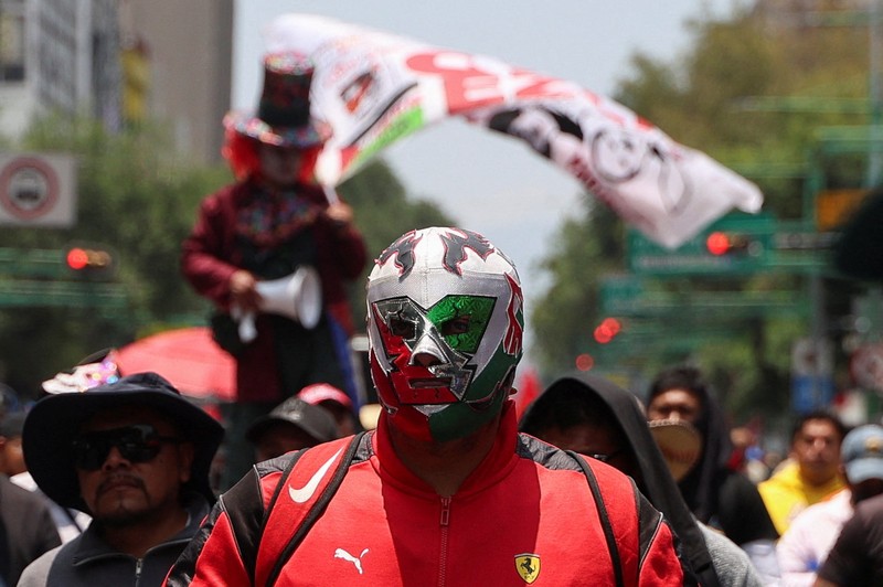 Para guru dari serikat Koordinasi Nasional Pekerja Pendidikan Meksiko (CNTE) berpawai menuju alun-alun Zocalo untuk menuntut upah dan pensiun yang lebih baik, dengan slogan