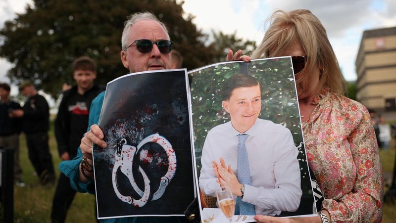 Para demonstran memegang dua gambar, satu gambar Henry Nowak dan satu lagi gambar borgol, selama protes di luar Kantor Polisi Pusat Southampton menyusul vonis terhadap Vikrum Digwa atas pembunuhan mahasiswa Henry Nowak, di Southampton, Inggris, 2 Juni 2026.