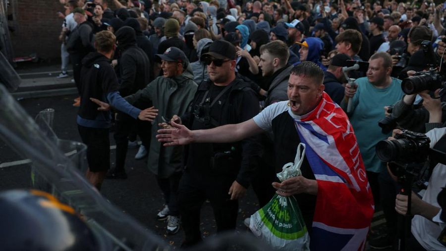 Para pengunjuk rasa berdiri menghadap petugas polisi selama demonstrasi menyusul vonis terhadap Vikrum Digwa atas pembunuhan mahasiswa Henry Nowak, di Southampton, Inggris, 2 Juni 2026. (REUTERS/Isabel Infantes)