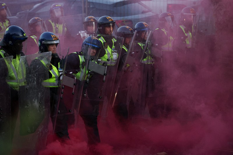 Para pengunjuk rasa berdiri menghadap petugas polisi selama demonstrasi menyusul vonis terhadap Vikrum Digwa atas pembunuhan mahasiswa Henry Nowak, di Southampton, Inggris, 2 Juni 2026. (REUTERS/Isabel Infantes)