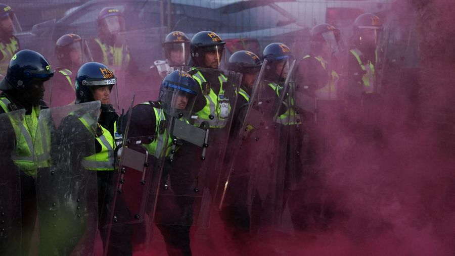 Para petugas polisi berjaga di tengah asap berwarna selama demonstrasi menyusul vonis terhadap Vikrum Digwa atas pembunuhan mahasiswa Henry Nowak, di Southampton, Inggris, 2 Juni 2026.