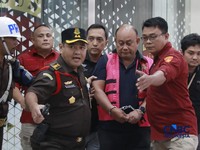 Penyidik Jaksa Agung Muda Bidang Pidana Khusus Kejaksaan Agung menggelandang mantan kepala Badan Gizi Nasional Dadan Hindayana ke dalam mobil tahanan yang terparkir di depan Gedung Jampidsus Kejagung, Jakarta Selatan, Rabu (3/6/2026). (CNBC Indonesia