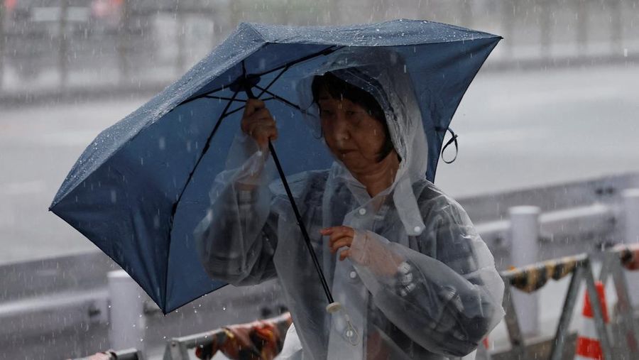 Seorang pejalan kaki berjalan menerobos hujan deras akibat Topan Jangmi di Tokyo, Jepang, 3 Juni 2026. (REUTERS/Kim Kyung-Hoon)