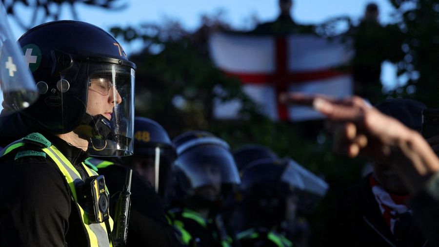 Seorang petugas polisi berjaga-jaga sementara seorang demonstran menunjuknya dengan jari saat demonstrasi menyusul vonis terhadap Vikrum Digwa atas pembunuhan mahasiswa Henry Nowak, di Southampton, Inggris, 2 Juni 2026.