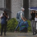 Seorang turis yang mengenakan jas hujan berjalan menerobos hujan deras akibat Topan Jangmi di Tokyo, Jepang, 3 Juni 2026. (REUTERS/Kim Kyung-Hoon)