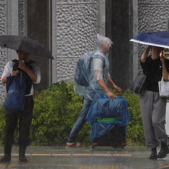 Seorang turis yang mengenakan jas hujan berjalan menerobos hujan deras akibat Topan Jangmi di Tokyo, Jepang, 3 Juni 2026. (REUTERS/Kim Kyung-Hoon)