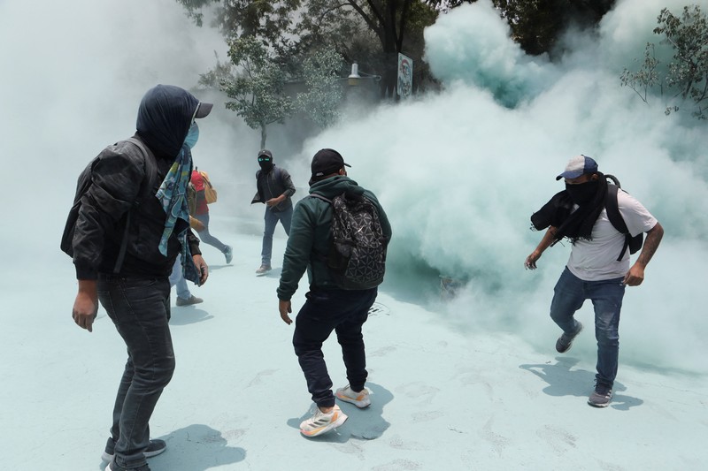 Para guru pembangkang dari Koordinasi Nasional Pekerja Pendidikan Meksiko (CNTE) berkumpul di luar salah satu titik akses ke kantor Sekretariat Pendidikan Publik (SEP) selama protes untuk menuntut upah dan pensiun yang lebih baik, dengan slogan