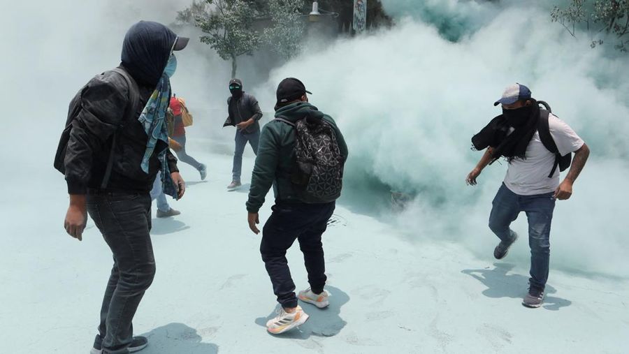 Para pembimbing pembangkang dari Koordinasi Nasional Pekerja Pendidikan Meksiko (CNTE) melangkah di tengah asap perangkat pemadam kebakaran nan digunakan polisi untuk membubarkan demonstran di luar Sekretariat Pendidikan Publik (SEP) selama protes untuk menuntut bayaran dan pensiun nan lebih baik, dengan slogan
