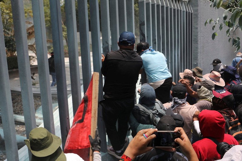 Para guru pembangkang dari Koordinasi Nasional Pekerja Pendidikan Meksiko (CNTE) berkumpul di luar salah satu titik akses ke kantor Sekretariat Pendidikan Publik (SEP) selama protes untuk menuntut upah dan pensiun yang lebih baik, dengan slogan