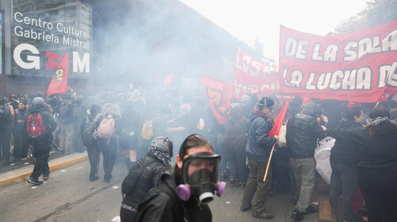 Para pengunjuk rasa bereaksi terhadap gas air mata yang digunakan oleh polisi anti huru hara selama protes terhadap kebijakan pemerintah Presiden Chili Jose Antonio Kast, di Santiago, Chili, 3 Juni 2026.