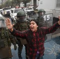 Polisi anti huru hara maju sementara seorang demonstran memberi isyarat dan meneriakkan slogan-slogan selama protes terhadap kebijakan pemerintah Presiden Chili Jose Antonio Kast, di Santiago, Chili, 3 Juni 2026. (REUTERS/Pablo Sanhueza)