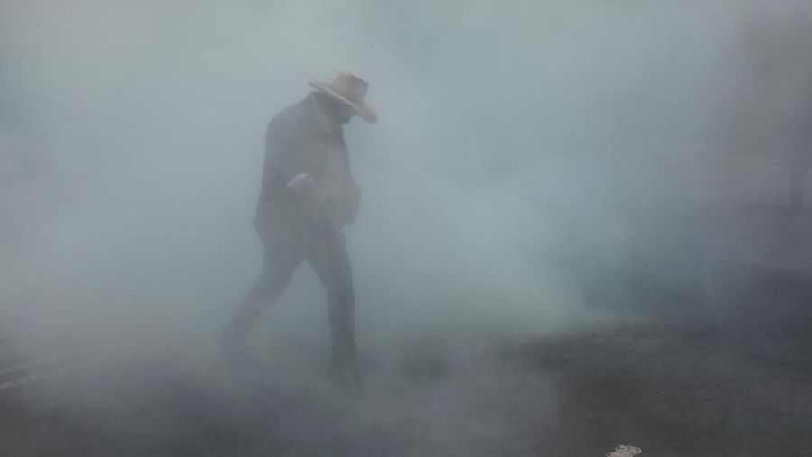 Seorang pembimbing pembangkang dari Koordinasi Nasional Pekerja Pendidikan Meksiko (CNTE) melangkah di tengah gas air mata di luar Sekretariat Pendidikan Publik (SEP) selama protes untuk menuntut bayaran dan pensiun nan lebih baik, dengan slogan