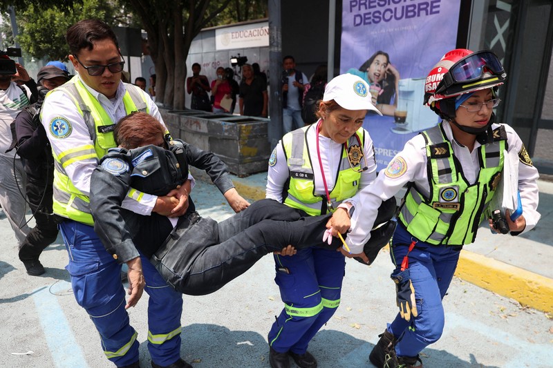Para guru pembangkang dari Koordinasi Nasional Pekerja Pendidikan Meksiko (CNTE) berkumpul di luar salah satu titik akses ke kantor Sekretariat Pendidikan Publik (SEP) selama protes untuk menuntut upah dan pensiun yang lebih baik, dengan slogan