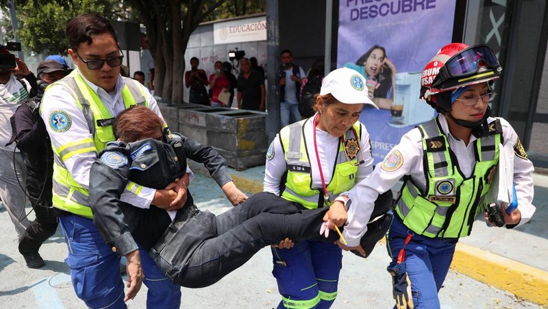 Seorang petugas polisi pembantu dievakuasi dari Sekretariat Pendidikan Publik (SEP) oleh petugas darurat setelah guru-guru pembangkang dari Koordinasi Nasional Pekerja Pendidikan Meksiko (CNTE) merusak gedung SEP selama protes untuk menuntut upah dan pensiun yang lebih baik, dengan slogan