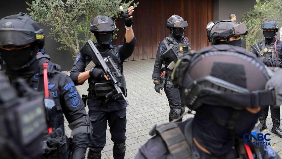 Sejumlah petugas kepolisian dari Brimob bersenjata laras panjang berjaga tepat di depan pagar pintu masuk saat penyidik Komisi Pemberantasan Korupsi (KPK) mendatangi kediaman pribadi Wakil Menteri Imigrasi dan Pemasyarakatan (Wamen Imipas) Silmy Kari