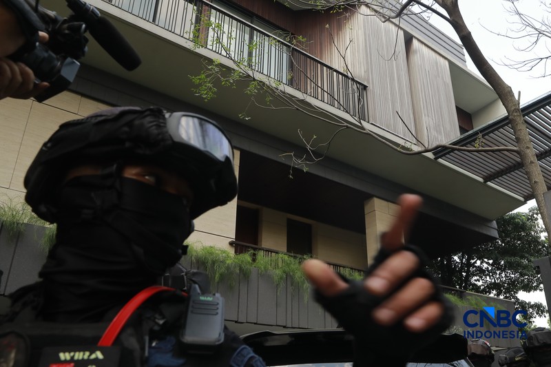 Sejumlah petugas kepolisian dari Brimob bersenjata laras panjang berjaga tepat di depan pagar pintu masuk saat penyidik Komisi Pemberantasan Korupsi (KPK) mendatangi kediaman pribadi Wakil Menteri Imigrasi dan Pemasyarakatan (Wamen Imipas) Silmy Karim di kawasan Kebayoran Baru, Jakarta Selatan, Jumat, (5/6/2026). (CNBC Indonesia/Muhammad Sabki)