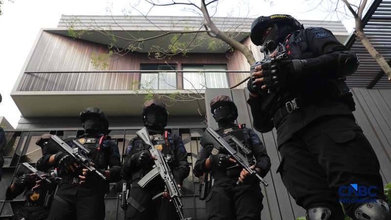 Sejumlah petugas kepolisian dari Brimob bersenjata laras panjang berjaga tepat di depan pagar pintu masuk saat penyidik Komisi Pemberantasan Korupsi (KPK) mendatangi kediaman pribadi Wakil Menteri Imigrasi dan Pemasyarakatan (Wamen Imipas) Silmy Karim di kawasan Kebayoran Baru, Jakarta Selatan, Jumat, (5/6/2026). (CNBC Indonesia/Muhammad Sabki)