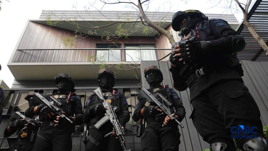 Sejumlah petugas kepolisian dari Brimob bersenjata laras panjang berjaga tepat di depan pagar pintu masuk saat penyidik Komisi Pemberantasan Korupsi (KPK) mendatangi kediaman pribadi Wakil Menteri Imigrasi dan Pemasyarakatan (Wamen Imipas) Silmy Kari