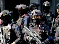 Sejumlah petugas kepolisian dari Brimob bersenjata laras panjang berjaga tepat di depan pagar pintu masuk saat penyidik Komisi Pemberantasan Korupsi (KPK) mendatangi kediaman pribadi Wakil Menteri Imigrasi dan Pemasyarakatan (Wamen Imipas) Silmy Kari