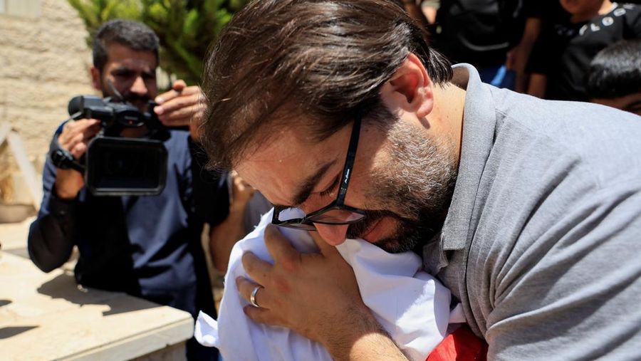 Ayah dan saudara laki-laki Sam Abu Haykal, seorang bayi Palestina berusia 7 bulan yang dibunuh oleh tentara Israel, membawa jenazahnya selama pemakamannya di Hebron di Tepi Barat yang diduduki Israel, 6 Juni 2026. REUTERS/Mussa Qawasma