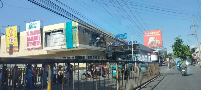 Polisi berkumpul di depan reruntuhan restoran cepat saji Jollibee setelah gempa bumi berkek magnitude 7,8 di Kota General Santos pada 8 Juni 2026. (AFP/EDWIN ESPEJO)