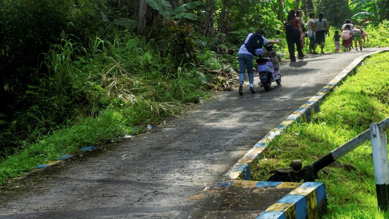 Orang-orang berjalan kaki saat mengungsi ke dataran tinggi setelah badan geofisika Indonesia mengeluarkan peringatan tsunami menyusul gempa bumi di lepas pantai selatan pulau Mindanao, Filipina, yang juga dirasakan di Tahuna, Kabupaten Kepulauan Sangihe, Provinsi Sulawesi Utara, Senin (8/6/2026). (REUTERS/Stenly Pontolawokang)