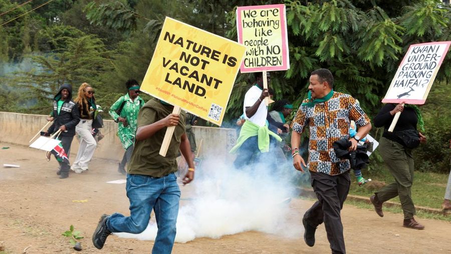 Para aktivis lingkungan bubar setelah petugas polisi anti huru hara melemparkan tabung gas air mata ke arah mereka selama demonstrasi menentang pengarahan lahan Taman Nasional Nairobi dan rencana relokasi Panti Asuhan Hewan Nairobi di Nairobi, Kenya,