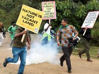 Para aktivis lingkungan bubar setelah petugas polisi anti huru hara melemparkan tabung gas air mata ke arah mereka selama demonstrasi menentang pengarahan lahan Taman Nasional Nairobi dan rencana relokasi Panti Asuhan Hewan Nairobi di Nairobi, Kenya,