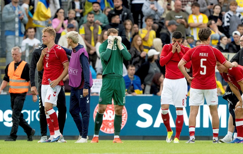 Para pemain dan staf Ukraina dan Denmark berkumpul setelah pertandingan dihentikan karena Christian Eriksen dari Denmark pingsan saat pertanidngan persahabatan di Stadion Stadion Odense, Denmark, Minggu (7/6/2026). (Bo Amstrup/Ritzau Scanpix via REUTERS)