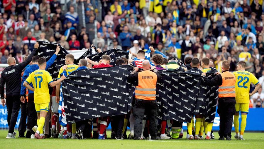 Para pemain dan staf melindungi Christian Eriksen dari Denmark saat ia meninggalkan lapangan untuk mendapatkan perawatan medis setelah pingsan saat pertanidngan persahabatan di Stadion Stadion Odense, Denmark, Minggu (7/6/2026). (Bo Amstrup/Ritzau Scanpix via REUTERS)