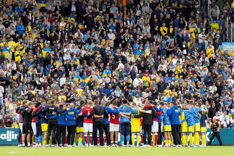 Para pemain dan staf Ukraina dan Denmark berkumpul setelah pertandingan dihentikan karena Christian Eriksen dari Denmark pingsan saat pertanidngan persahabatan di Stadion Stadion Odense, Denmark, Minggu (7/6/2026). (Bo Amstrup/Ritzau Scanpix via REUTERS)